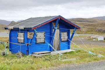 A fragile country house being held up by ropes